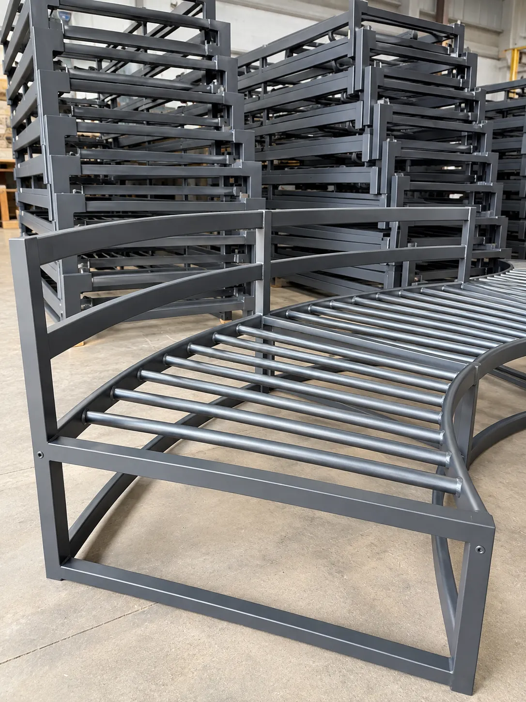 Finished dark aluminum seating frames stacked in the shop