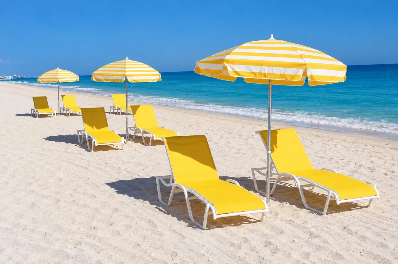 Yellow striped umbrellas and matching lounges on the beach